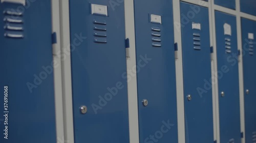 Row Of Blue Metal Lockers In The School Hallway. School Lockers. - close up shot (sideways) photo