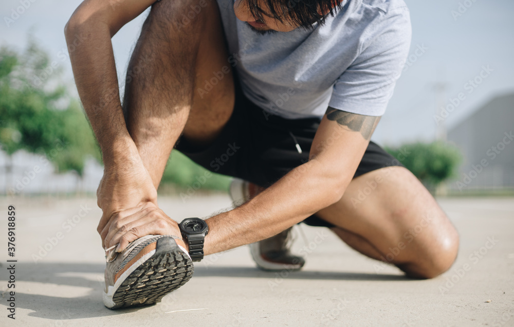 Naklejka premium Sports man suffering for ankle pain from exercise