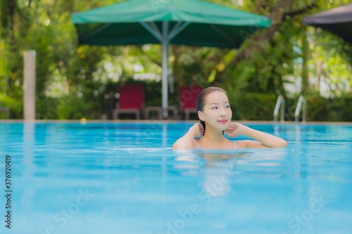 Portrait beautiful young asian woman enjoy relax smile leisure around outdoor swimming pool © siraphol