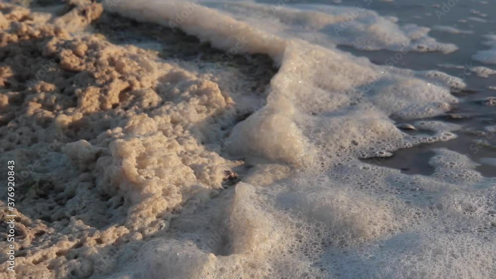 Beach sea sand at the sunset. Sea foam in the wind Beach sea sand at the sunset. Sea foam in the wind