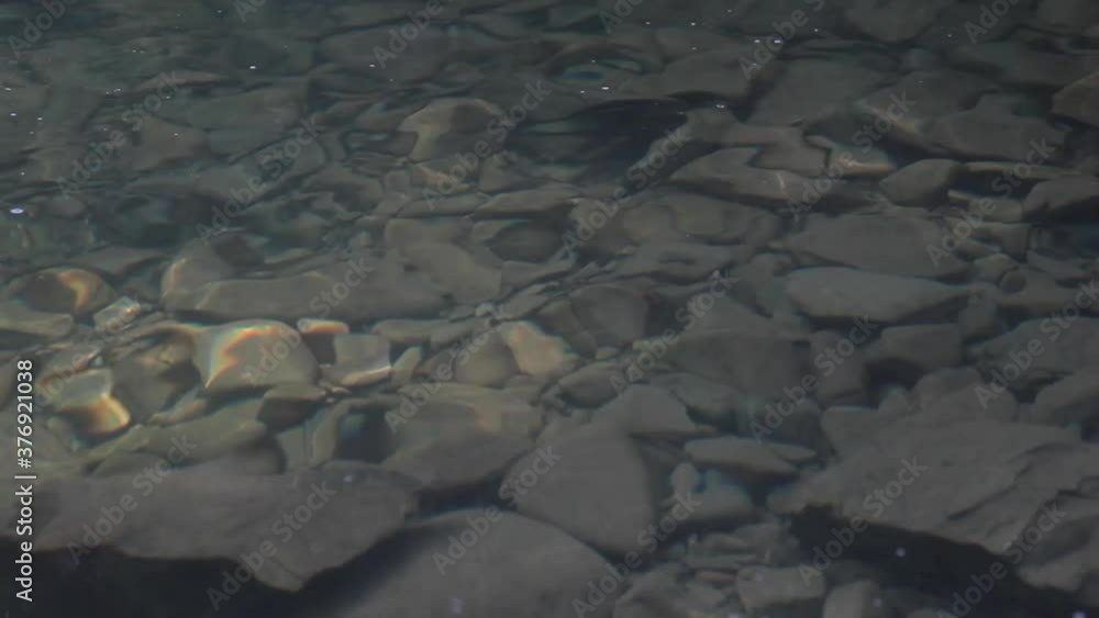 Clean and clear water in mountains waterfall. Rocks under the water Clean and clear water in mountains waterfall. Rocks under the water