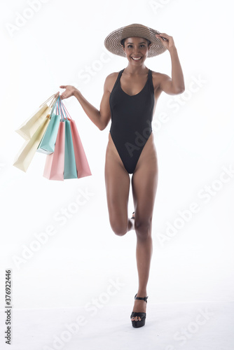 Happy asian shopping woman wear swiming suit hold shopping bags in hand enjoy in lifestyle shopping concept, in midnight sales and discount on seales. photo