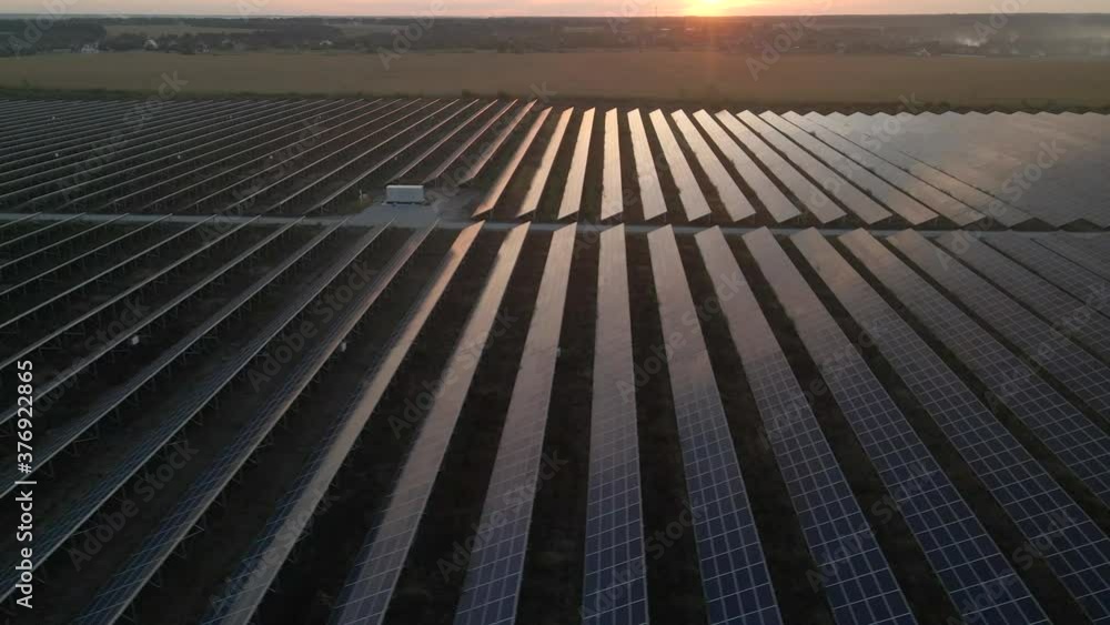 Aerial drone view into large solar panels at a solar farm at bright sunset. Solar cell power plants. footage video 4k. Aerial drone view into large solar panels at a solar farm at bright sunset. Solar cell power plants. footage video 4k.