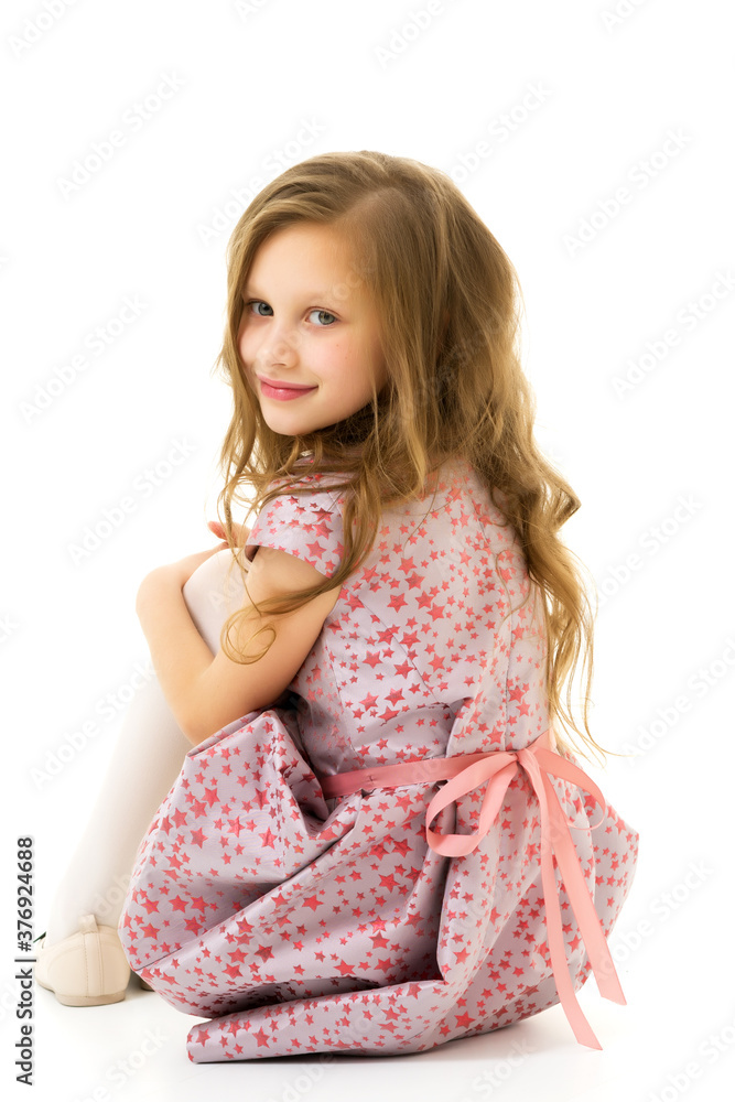 Beautiful blonde in a dress sitting on the floor hugging her knees. Beautiful blonde in a dress sitting on the floor hugging her knees.