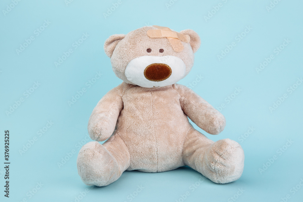 Stuffed Bear animal as a symbol of children healtcare concept isolated on blue background. Stuffed Bear animal as a symbol of children healtcare concept isolated on blue background.