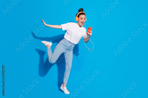Full length body size view of nice attractive lovely funny funky glad cheerful girl listening soul rock different single dancing having fun isolated on bright vivid sine vibrant blue color background