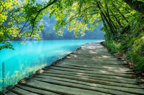 Plitvice lakes in Croatia. National Park in summer. Waterfalls and lakes among the forest. Footpath for hiking. Croatian travel image.