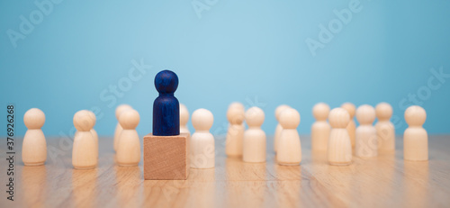 Wooden figure standing on the box for show influence and empowerment. Concept of business leadership for leader team, successful competition winner and Leader with influence photo