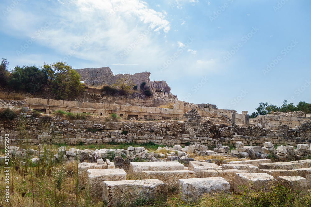 Remains of walls surrounding Byzantine palace in ancient city Elaiussa Sebaste, near Kızkalesi, Turkey. Ruins of palace itself are on hill (background). City was abandoned in medieval