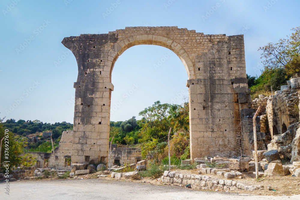 Massive arch near building of Roman theater in ancient city Elaiussa Sebaste, near Kizkalesi, Turkey. Building was built in 1 century AD, probably as part of villa residence or aqueduct
