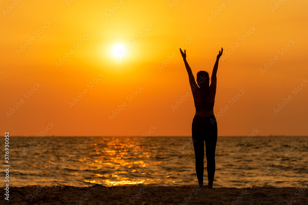 Silhouette woman raise hands feeling relax and freedom. People running and workout in sunset background. 