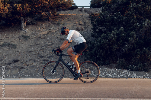 Fototapeta Naklejka Na Ścianę i Meble -  Cycling sport athlete man riding on coastal road