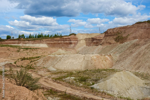 Panoramic view onto quarry with open mining. It can be seen the working walls of the pit, worked out areas, dumps of useful & waste earth resources