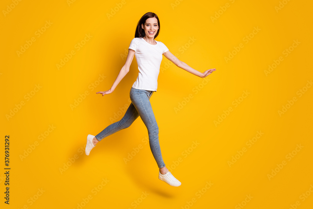 Full length body size view of her she nice attractive pretty cheerful cheery thin girl jumping walking strolling enjoying leisure isolated bright vivid shine vibrant yellow color background