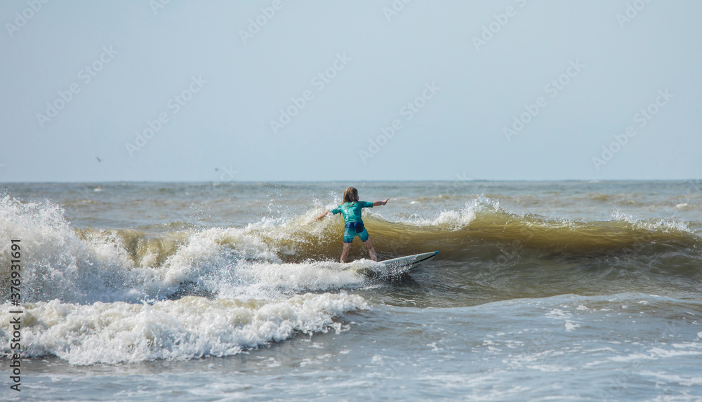Young child surfing waves on the Atlantic Ocean off South Carolina. Young child surfing waves on the Atlantic Ocean off South Carolina.