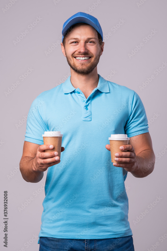 Happy delivery man with a two cups of coffee Happy delivery man with a two cups of coffee