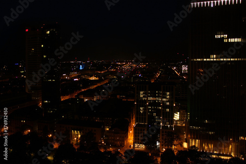 beautiful view from a height, from the window to the night modern European city of Frankfurt am Main with lights, tall skyscrapers, the concept of global business, traffic
