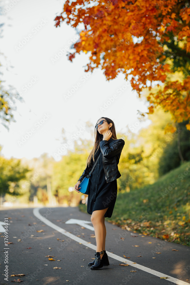Girl with a sweet smile posing in a warm autumn on the road. Autumn background. Girl with a sweet smile posing in a warm autumn on the road. Autumn background.