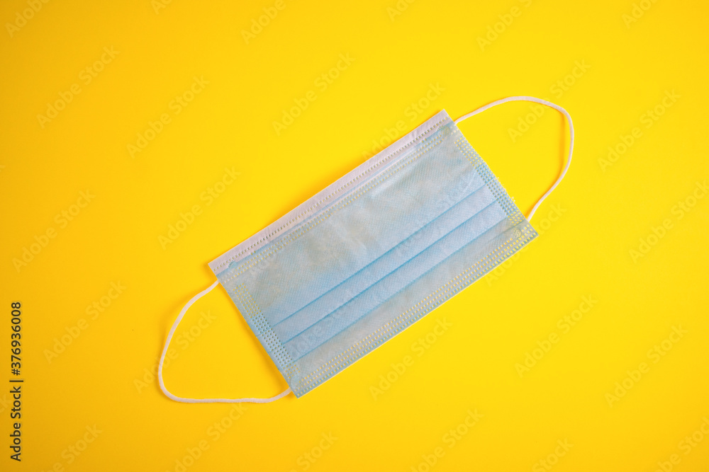 PANDEMIC PROTECTIVE MASK ON YELLOW BACKGROUND PANDEMIC PROTECTIVE MASK ON YELLOW BACKGROUND