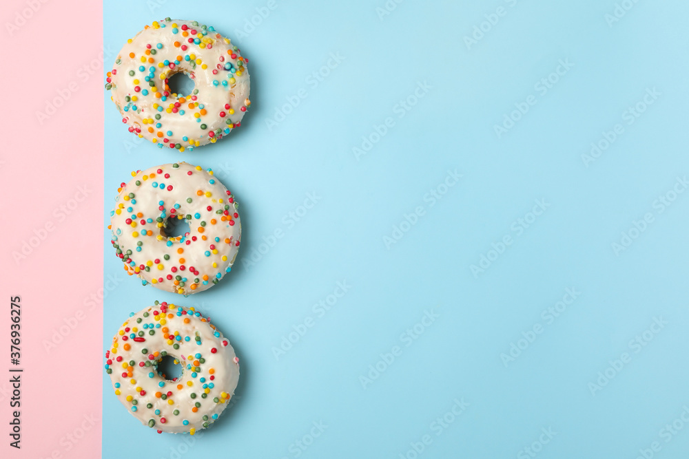 Tasty donuts on two tone background, top view