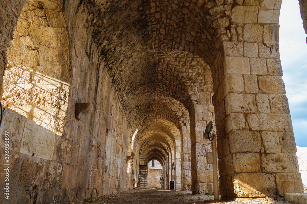 Corridor inside of medieval fortress Kizkalesi, city Kizkalesi, Turkey. There are stone arch colonnade & embrasure. Fort founded in antiquity by pirates, then belonged to Byzantines & after to Osmans