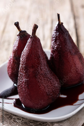 Poached pears in red wine on wooden table