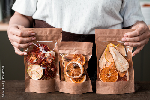Quadro em tela Close-up of unrecognizable woman presenting packages of sweet dried fruit mixtur