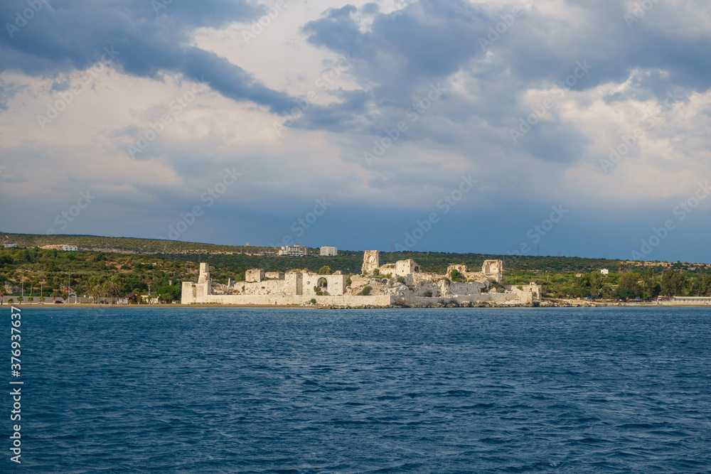Panoramic view onto medieval castle Korykos, walls & towers. Object is in tentative UNESCO List. Resort city Kizkalesi on background. Located in Southern Turkey on Mediterranean sea shoreline Panoramic view onto medieval castle Korykos, walls & towers. Object is in tentative UNESCO List. Resort city Kizkalesi on background. Located in Southern Turkey on Mediterranean sea shoreline