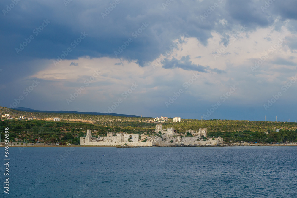 Panoramic view onto medieval castle Korykos, its walls & towers. Object is in tentative UNESCO List. Modern city Kizkalesi on background. Located in Southern Turkey on Mediterranean sea coastline