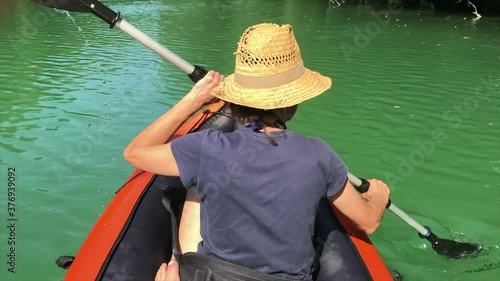 Back view of a Girl rowing  in the Soca river, Slovenia photo