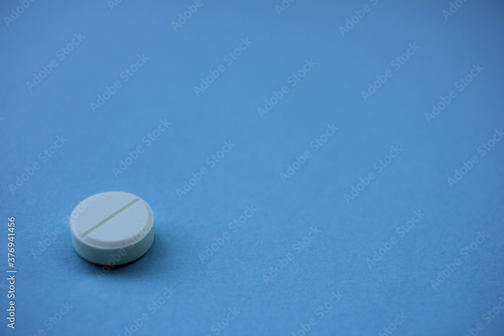 Single white pill on a blue background with copy space Single white pill on a blue background with copy space