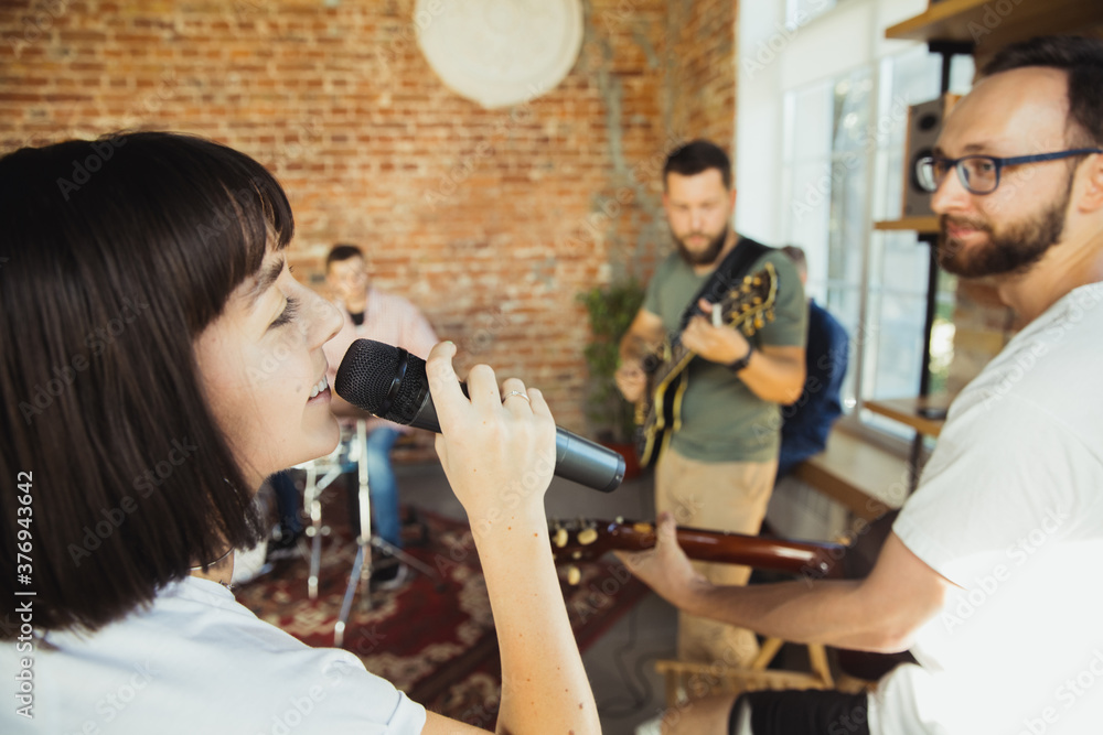 Inspiration. Musician band jamming together in art workplace with instruments. Caucasian men and women, musicians, playing and singing together. Concept of music, hobby, emotions, art occupation. Inspiration. Musician band jamming together in art workplace with instruments. Caucasian men and women, musicians, playing and singing together. Concept of music, hobby, emotions, art occupation.