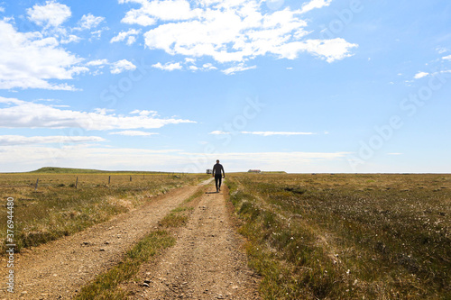 woman walking on an Icelandic dirt road © GufinnaBerg