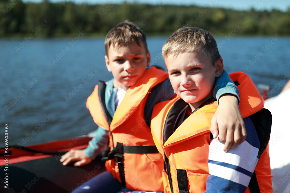 Fototapeta premium Two children in life jacket on boat