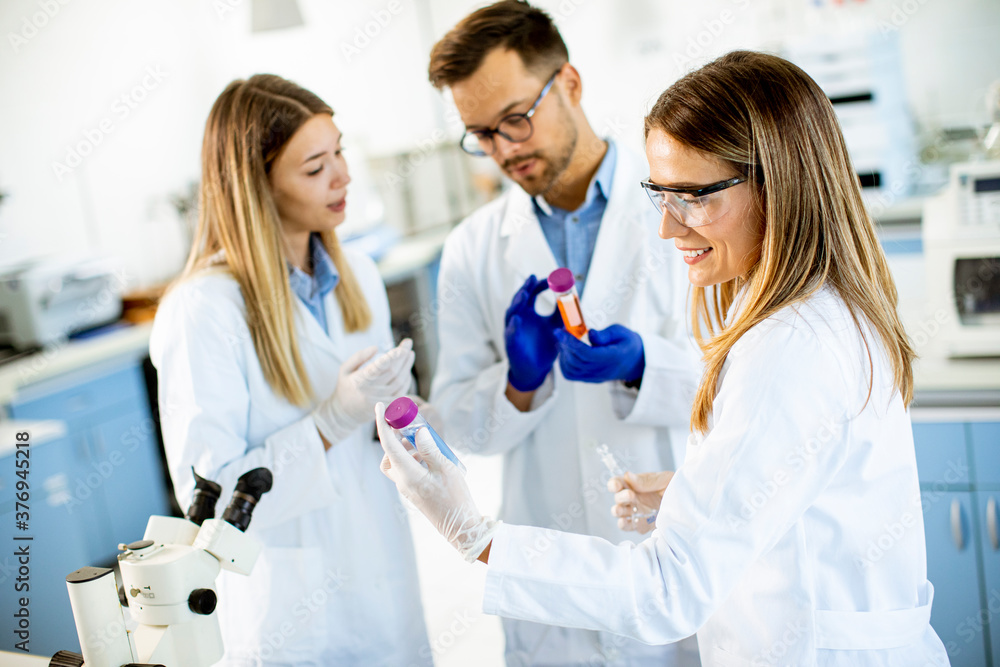 Group of young researchers analyzing chemical data in the laboratory Group of young researchers analyzing chemical data in the laboratory