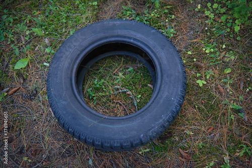 Old car tire on the background of grass close-up.