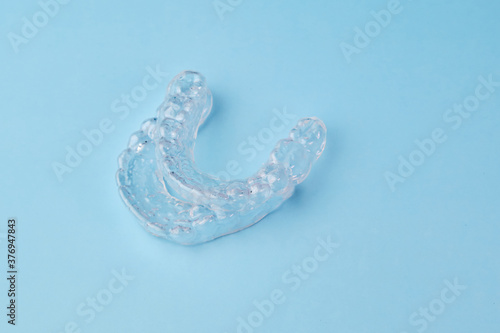 Two removable braces on the blue background. Invisible aligners for whitening teeth at home by yourself.