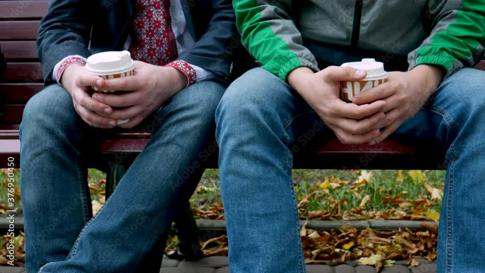 Coffee break two colleagues on park bench in autumn. Different paper cups with drink. Friendship concept Coffee break two colleagues on park bench in autumn. Different paper cups with drink. Friendship concept
