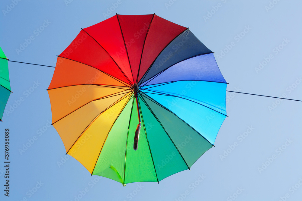 One multi-colored umbrella against the blue sky. Autumn concept, rain