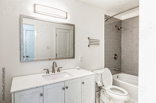 Freshly renovated bathroom with shower  toilet  mirror  faucet and sink