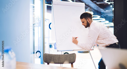 Office manager writing with marker on flipchart