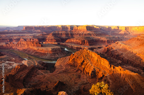 bright sunrise in the american red canyons in summer with a river in the middle