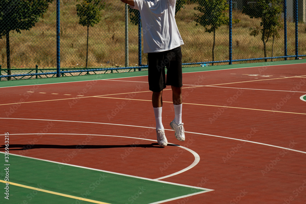 Young man on basketball court dribbling with ball