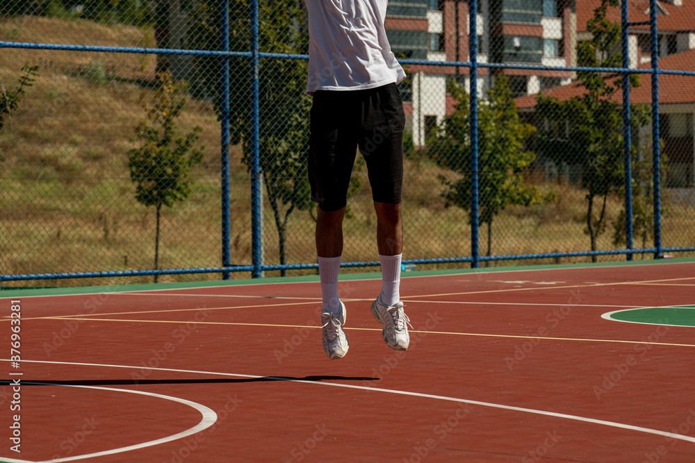 Young man on basketball court dribbling with ball
