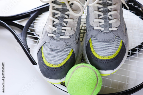 sports fashion. footwear for sports. sneakers and tennis rackets on white background © Palanga