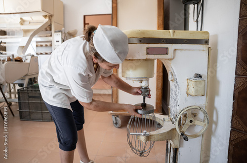 Photography Unrecognizable baker woman setting an industrial beater