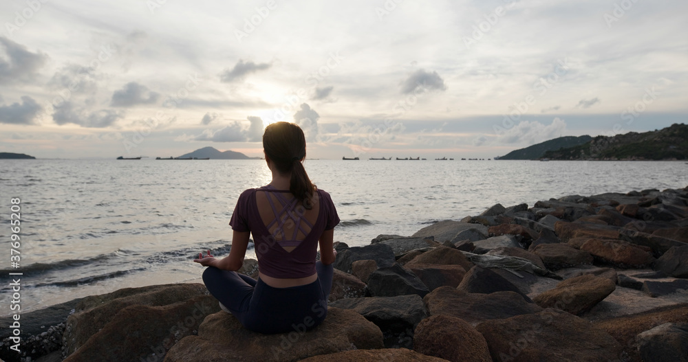 Woman do yoga and sit at seaside Woman do yoga and sit at seaside