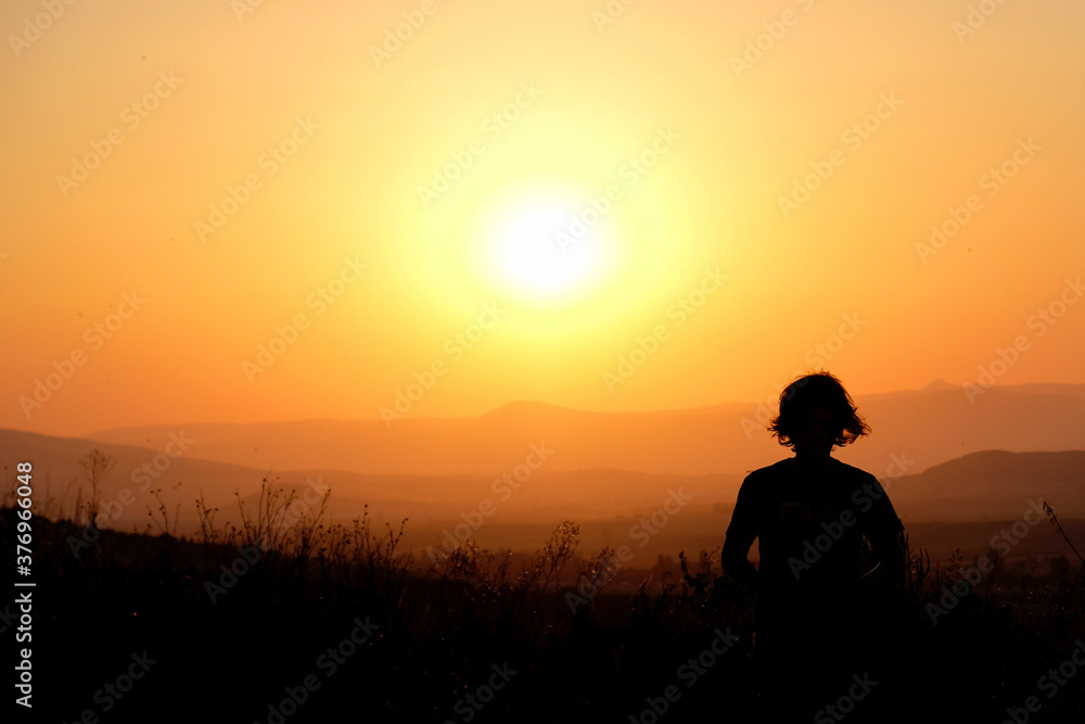 Silhouette of a young man at sunset