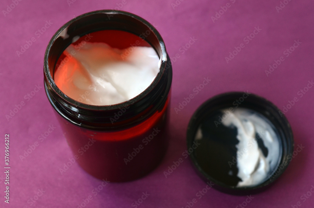 Opened jar of white cream for body and face care
