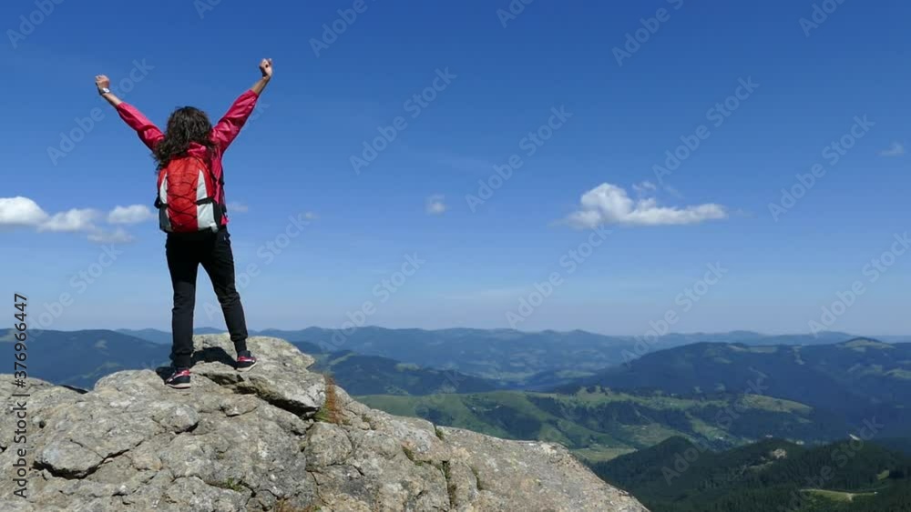 Girl on top of the mountain with a backpack. Rejoice at achievement Girl on top of the mountain with a backpack. Rejoice at achievement